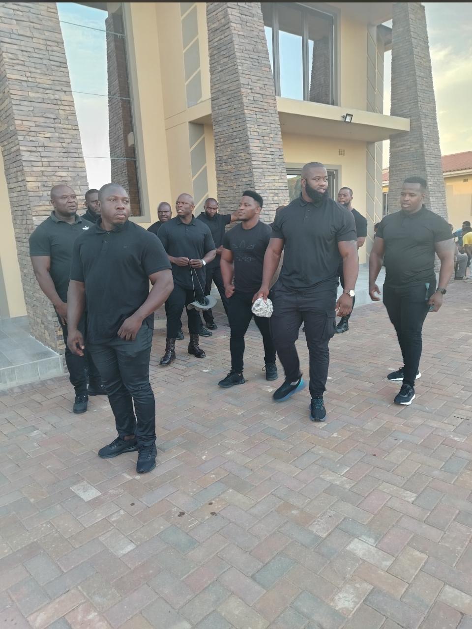 KM VIP large team deployment — over twelve officers in all-black uniform
